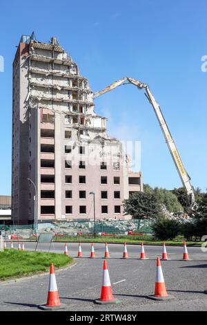 High rise block of flats, Irvine, Ayrshire, Scotland, UK, being demolished by a mechanical crane. Stock Photo