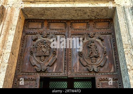 The two wooden coats of arms carved on the portal of the church of Santa Maria della Carità, also known as della Scopa, in Ascoli Piceno. Marche Stock Photo