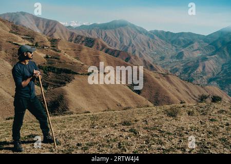 November 30th 2022. Tehri Garhwal, Uttarakhand India. A lone hiker in the Himalayas of Uttarakhand, using a walking stick, embarking on an exploration Stock Photo