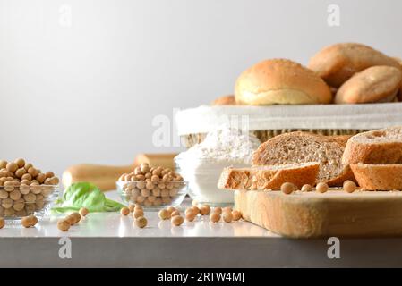 Bread with soy flour on kitchen bench with soy beans and white isolated background. Front view. Stock Photo