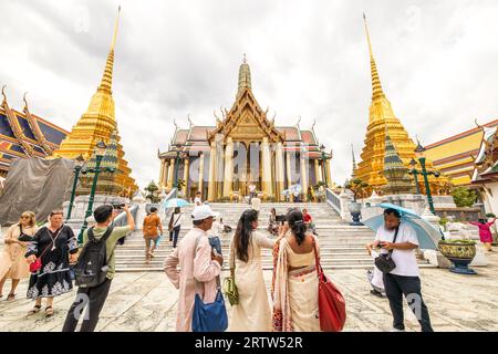 Bangkok, Thailand - SEPTEMBER 13, 2023: A group of tourists visit the ancient golden temple at Wat Phra Kaew, a top tourist attraction in Asia. Stock Photo