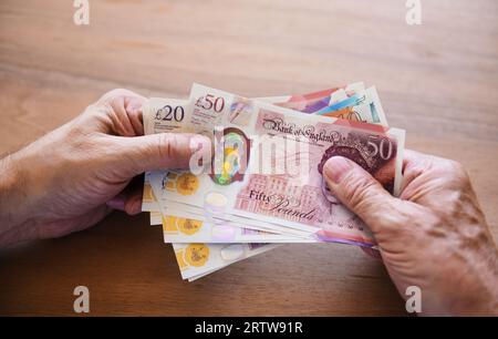 Holding British pound notes Stock Photo