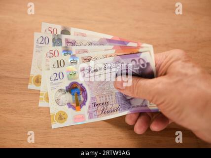 Holding British pound notes Stock Photo