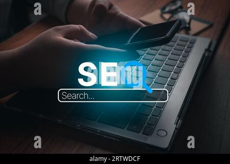 Woman using smartphone with VR SEO text interface. SEO Search Engine Optimization concept. Ranking traffic on website. Digital marketing business. Stock Photo