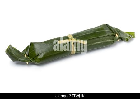 Single whole Lemper wrapped in banana leaves, an Indonesian savoury snack made of glutinous rice  close up isolated on white background Stock Photo