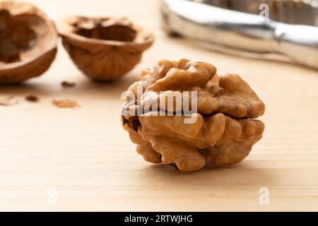 Single peeled walnut close up and shells and nutcracker on the background Stock Photo