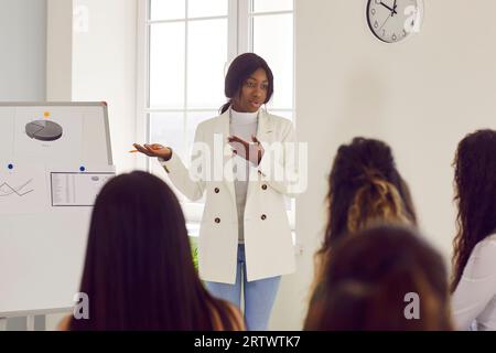 Woman showing her women colleagues financial data in office analyzing company growth on meeting Stock Photo