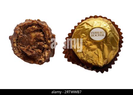Ferrero Rocher chocolates, one wrapped one unwrapped and bitten into isolated on white background - whole hazelnut in milk chocolate and nut croquante Stock Photo