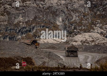 Big hauling trucks against the rugged texture on the mountains near Grasberg open pit mine in Papua, Indonesian high lands Stock Photo