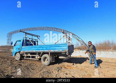 LUANNAN COUNTY, China - December 1, 2021: farmers weld steel skeleton greenhouses in farmland, North China Stock Photo