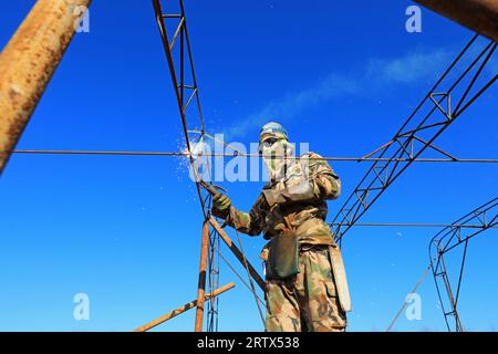 LUANNAN COUNTY, China - December 1, 2021: farmers weld steel skeleton greenhouses in farmland, North China Stock Photo