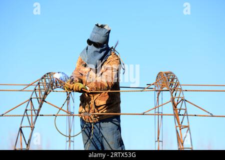 LUANNAN COUNTY, China - December 1, 2021: farmers weld steel skeleton greenhouses in farmland, North China Stock Photo