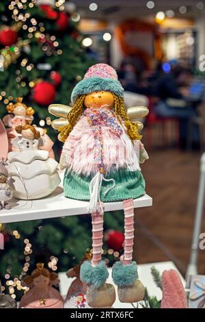 cute toy angels in a fur coat near the Christmas tree. Family Christmas Stock Photo