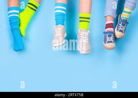 Odd Socks Day, Lonely Sock Day.  Anti-Bullying Week, Down syndrome awareness. Child legs wearing different pair of mismatched socks on high-colored ba Stock Photo