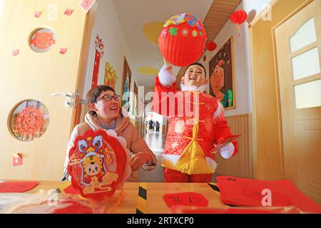 LUANNAN COUNTY, China - December 31, 2021: A child and his mother chose lanterns together, North China Stock Photo