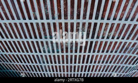 textured background of a metal lattice with a dark background, geometric two-color abstraction with oblong holes, shabby iron dense mesh Stock Photo