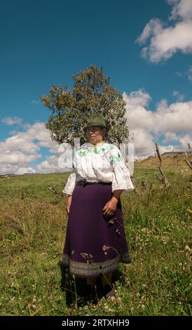 Cangahua, Cayambe / Ecuador - September 12 2023: Portrait of elderly indigenous woman from Cayambe walking through the field during the day Stock Photo