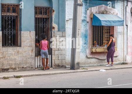 Havana, Cuba, 2023, Two Cuban women by metal grates or grilles that protective devices in private homes. Stock Photo