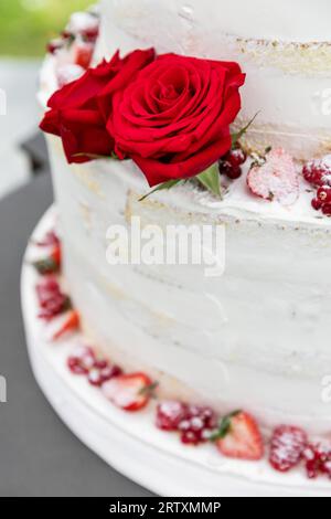 White wedding cake with real roses decorationsh roses Stock Photo