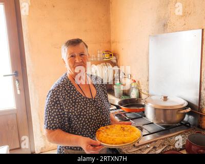 Portrait of elderly woman cooking a traditional Spanish tortilla at home in her kitchen, Galicia, Spain Stock Photo