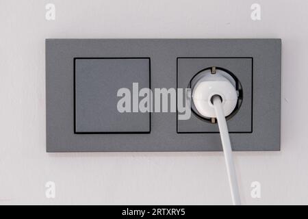 Close up light switch and plug socket on the wall. Stock Photo