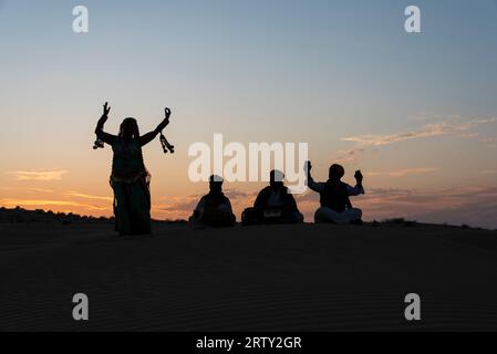 Silhouette of tribal dancers on the sand dunes of Jaisalmer, Rajasthan, India Stock Photo