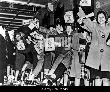 New York, New York   1945. A line of teenage girls, holding Song Hits magazine, waiting for singer Frank Sinatra to arrive at the Paramount Theatre in New York City. Stock Photo