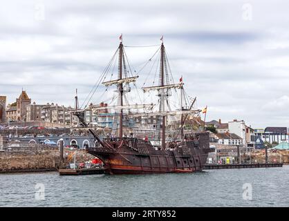 Visitors explore the decks of the El Galeon berthed at the Barbican Pontoon in Plymouth. The full size replica of a 17th century Spanish galleon is a Stock Photo