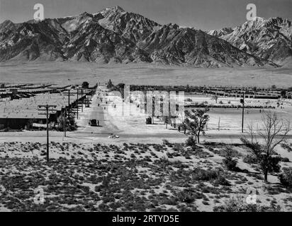 Owens Valley, California     1943 View from a guard tower of the Manzanar Relocation Center, one of the smaller Internment camps for Japanese-Americans. Photograph shows the western side of the grounds with the Sierra Nevada Mountains. At its peak, Manzanar held around 10,000 inmates, with the first inmates arriving in 1942, and the last leaving in 1945. Today, it is preserved as a National Historic Site. Photograph by Ansel Adams. Stock Photo