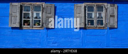 External wall with two windows of old wooden blue country house Stock Photo