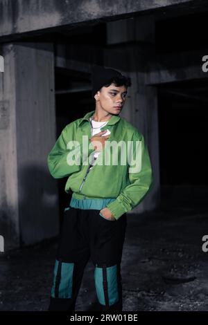 an Asian man wearing a green jacket and black beanie in an old building Stock Photo