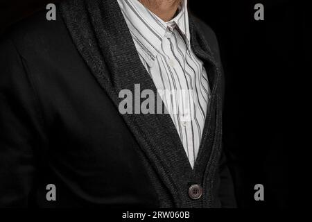 Men's fashionable business style clothing white shirt and black jumper on a dark background. Stock Photo