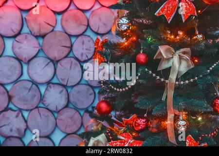 Christmas tree decorated with bows, balloons and toys, bright beautiful holiday atmosphere on a wooden background of the interior. Stock Photo