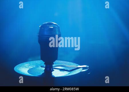 Hookah head bowl smoking object in blue light close-up. Stock Photo