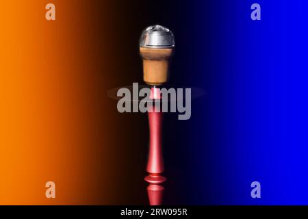 Clay object hookah head smoking on a black background in orange and blue neon light color. Stock Photo