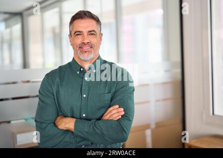 Smiling 40 years old middle aged business man standing in office, portrait. Stock Photo