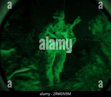 Dark, night vision and soldier in the military, war or mission for army with surveillance, security or agent of government. Green, man or person with Stock Photo