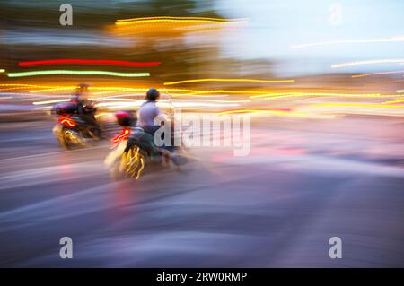 Abstract blurry image of a scooters driving at night Stock Photo