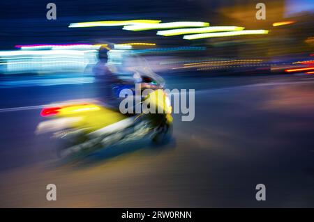 Abstract blurry image of a scooter driving at night Stock Photo