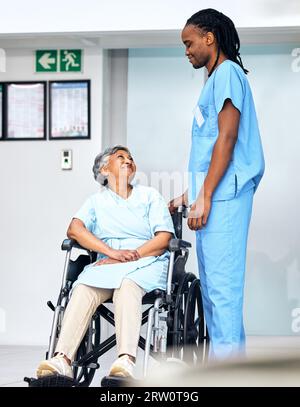 Healthcare, wheelchair and senior patient with her nurse in an assisted living home for care or service. Medical, smile and a black man caregiver Stock Photo