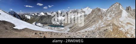 Scenic panorama of lake below highest mountain peaks in Ala Archa national park in Tian Shan mountain range in Kyrgyzstan Stock Photo