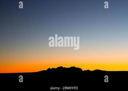 The silhouette of the boulders of the Olgas at sunset on a clear winter#39, s evening in Northern Territory, Australia Stock Photo