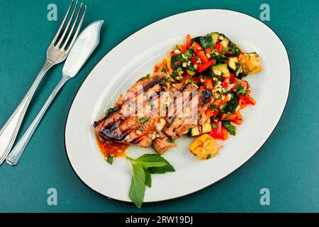 Grilled tuna steak served with vegetables salad on a plate Stock Photo