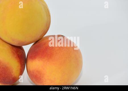 Peaches stacked in three on a white background. Stock Photo