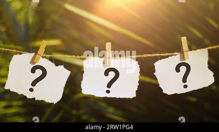 Question mark on paper concept on clip, education and business, searching for answers, thinking to solve a problem, having doubts Stock Photo