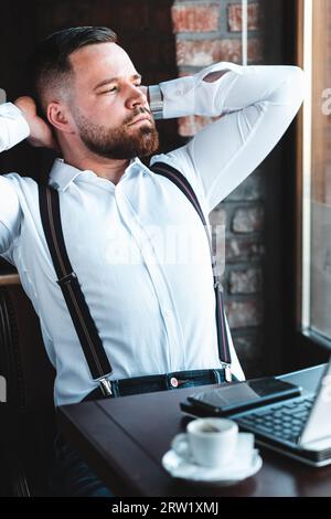 Portrait of a young businessman, leaning on the chair, thinking Stock Photo