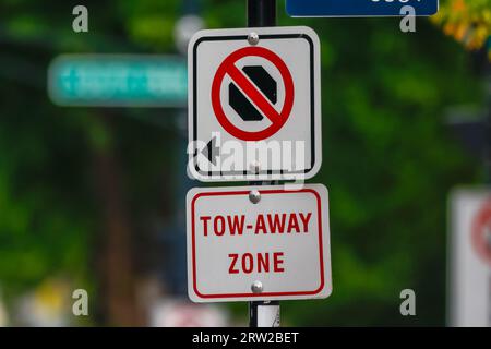 NO PARKING and TOW AWAY ZONE in RED Bold Text with an ARROW indicating the restricted zone. Stock Photo