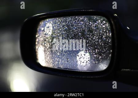 Raindrops on the rearview mirror of the car Stock Photo