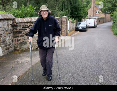 Elderly man out walking listening to music via headphones Stock Photo