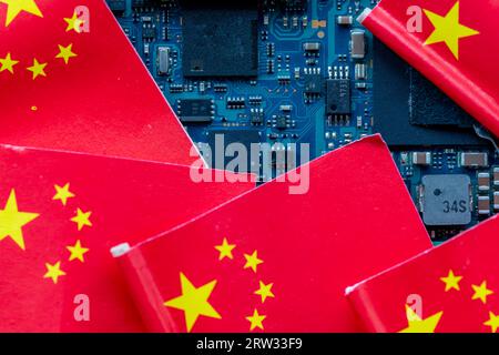 A Chinese technology concept with Chinese flags on top of a semi conductor circuit board. Stock Photo